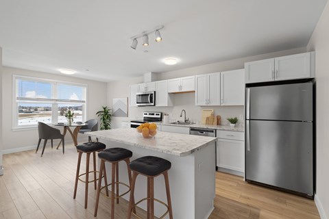 A kitchen with a white countertop and stainless steel appliances.